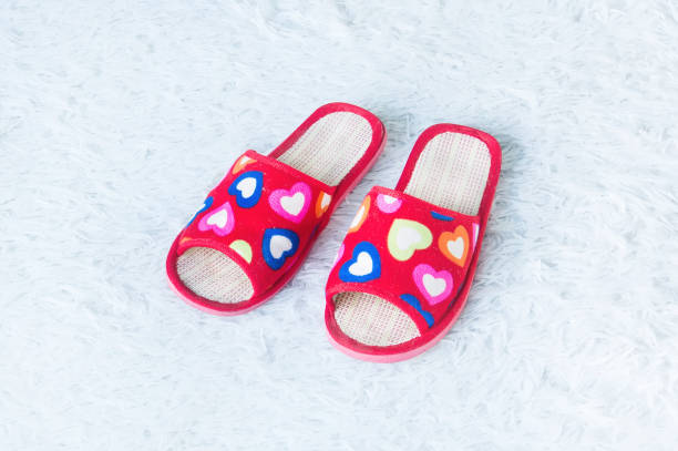 istock Pink slippers on white doormat 824608574