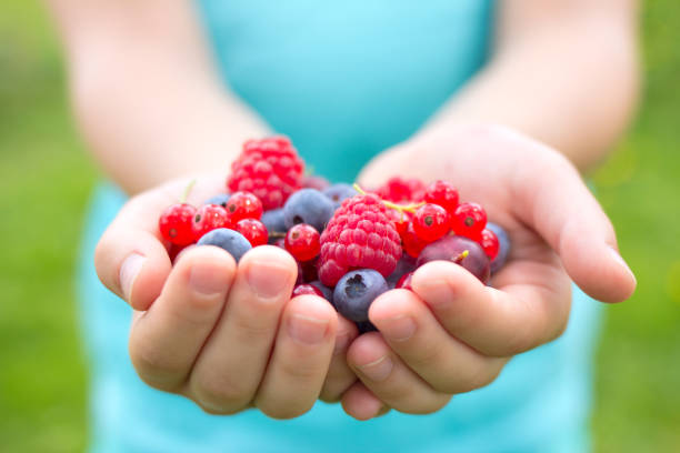 istock girl holding fresh fruits 824609440