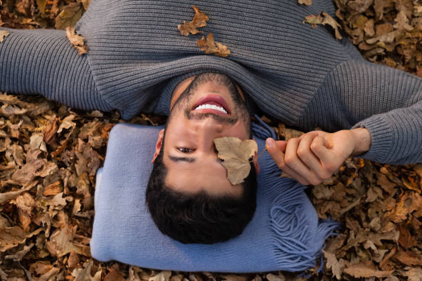 istock Overhead of man lying on autumn leaves 824609940