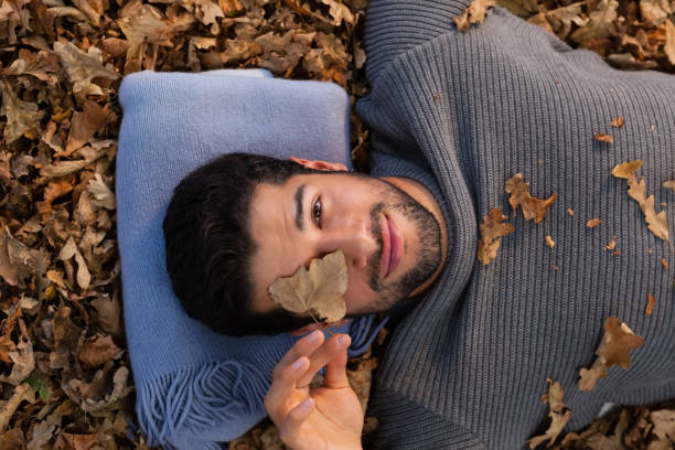 istock Overhead of man lying on autumn leaves 824609966