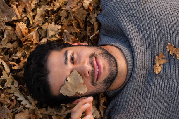 istock Overhead of man lying on autumn leaves 824610088