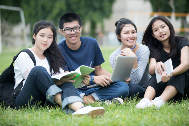 istock Asian Group of students sharing with the ideas for working on the campus lawn 824611662