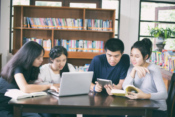 istock Asian Group of students sharing with the ideas for working on the campus lawn 824612170