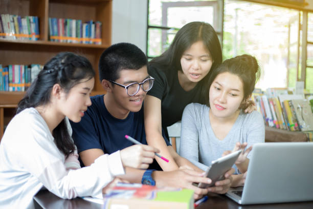 istock Asian Group of students sharing with the ideas for working on the campus lawn 824612402