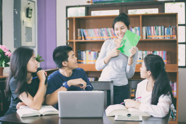 istock Asian Group of students sharing with the ideas for working on the campus lawn 824612500