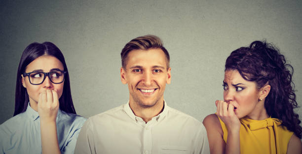 istock Happy man and two women anxiously looking at him 824612948