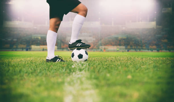 soccer or football player standing with ball on the field for Kick the soccer ball soft focus and selective focus on grass stock photo