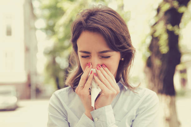 istock Woman with allergy symptoms blowing nose 824613300