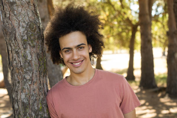 istock Portrait of man leaning on tree trunk 824614126