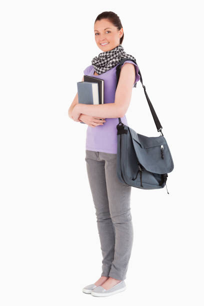 istock Attractive student holding books and her bag while standing 824617684
