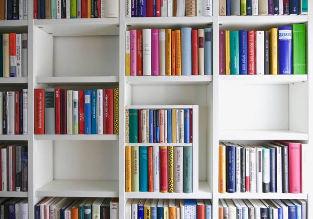 заполненные полки книг и некоторые части пусты: пространство для копирования - book book spine library bookstore стоковые фото и изображения