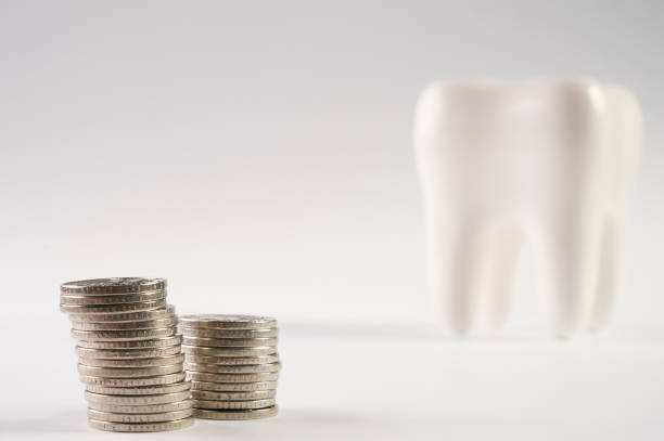 istock Tooth and stacked coins isolated on white background with copy space. Financial Concept Dentist Money concept 824636034