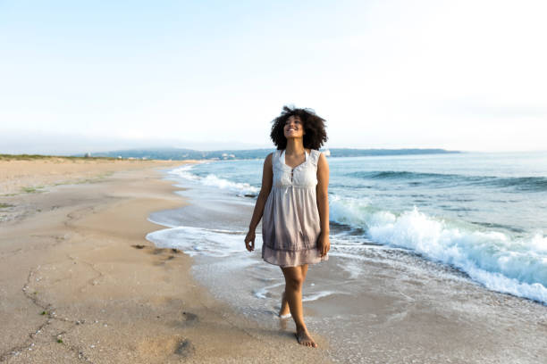 istock African woman walking on beach alone 824640118