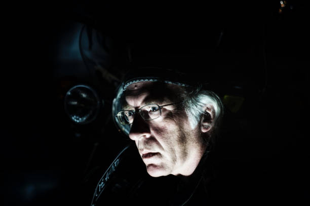 istock man in front of motorcycle lit from below 824640596