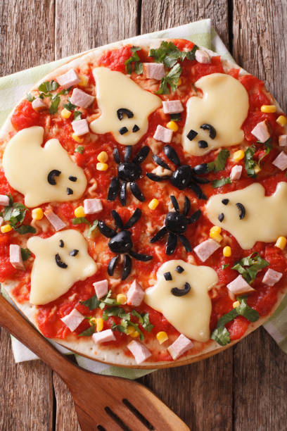 istock pizza for Halloween with ham, cheese and olives close-up. vertical top view 824641036