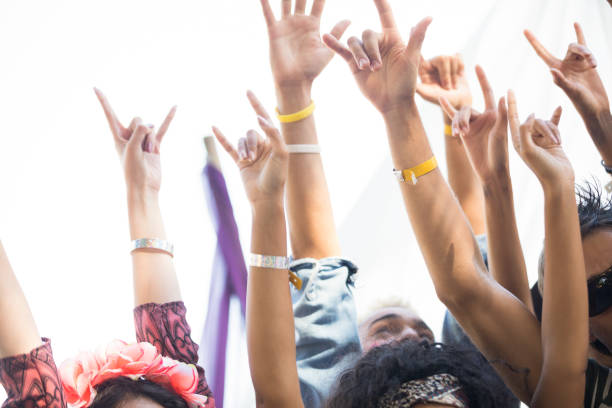fãs de gesticular sinal de chifre com braços levantados no festival de música - horn of africa people men women - fotografias e filmes do acervo