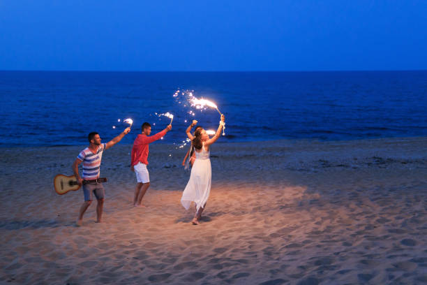 istock Friends celebrating with flaming torches on beach 824641302