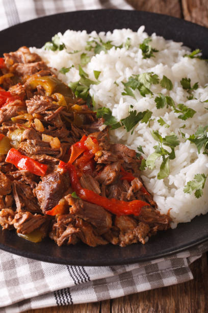 istock ropa vieja: beef stew in tomato sauce with vegetables and rice garnish close-up. vertical 824641408
