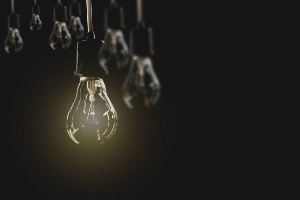 istock Hanging light bulbs with glowing one on dark background. Idea and creativity concept with light bulbs. 824644436