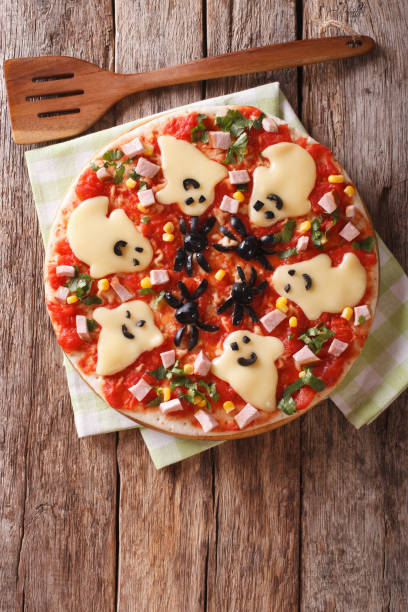 istock Halloween Food: Pizza with ghosts and spiders close-up. vertical top view 824649422