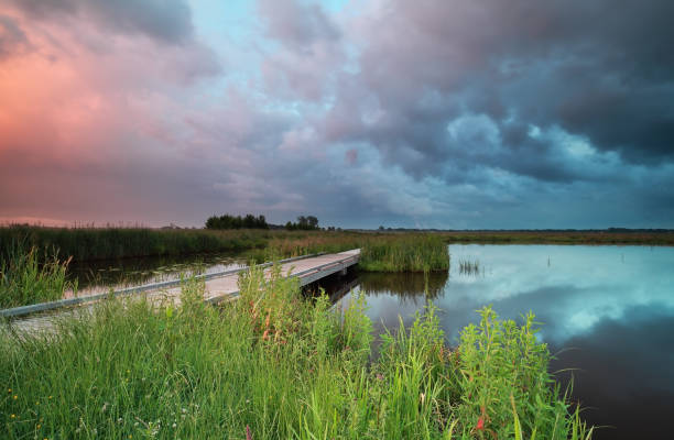 istock stormy sunset on river with biking bridge 824649998