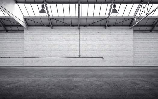Empty storehouse interior iluminated by spotlights and natural light from roof windows. 