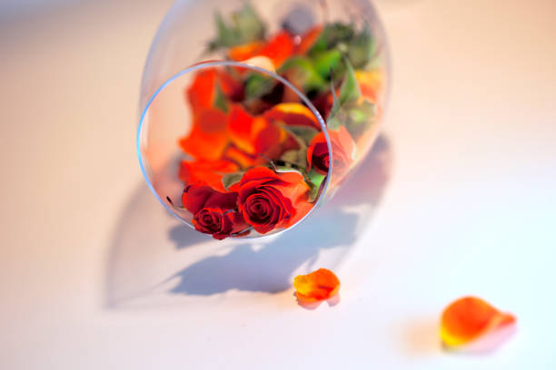 istock Glass vase filled with red rose petals. Aromatherapy concept. 824673690
