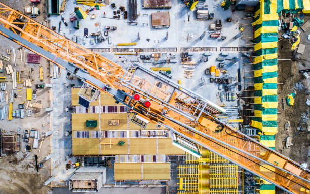 Aerial Photo of Busy Construction Site Nadir view of an industrial site, with cranes, concrete work, and more. tower crane stock pictures, royalty-free photos & images