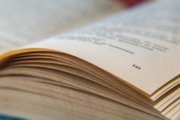 istock Open old book. Yellowed pages. Page number 143. Paper texture. Macro 824676948