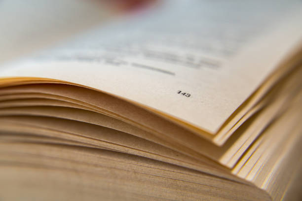istock Open old book. Yellowed pages. Page number 143. Paper texture. Macro 824676952