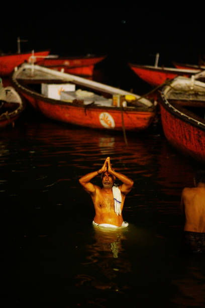Varanasi, India - January 30, 2016: The pilgrims offered flowers and burning candles to the Ganges River before dawn, and washed their bodies with the Ganges River. Varanasi is the holy town of Hinduism.