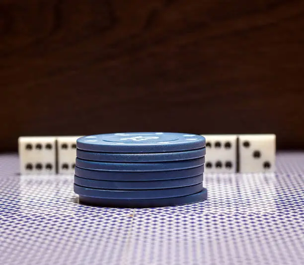 Photo of Poker chips and dominoes on the mirroring surface