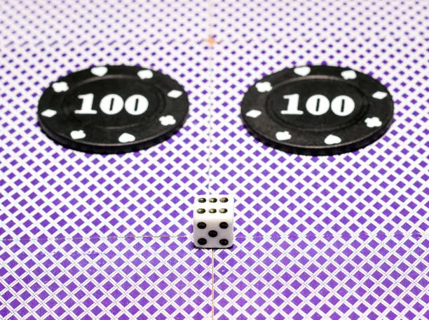 Photo of dice and poker chips on the back of the playing cards