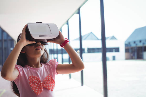 istock Schoolgirl using virtual reality glasses in corridor 824697010