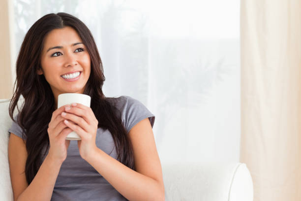 istock smiling woman holding a cup looking at the ceiling 824697102