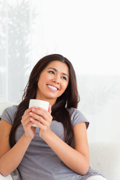 istock charming woman holding a cup looking at the ceiling 824697106