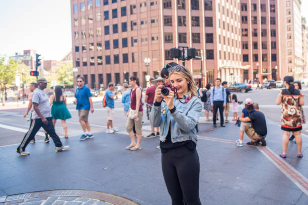 Tourist taking photos at the historical site of the Boston Massacre BOSTON, MA, July 2, 2017: Stylish young woman takes photos at the site of the Boston Massacre downtown. Boston has many historically significant sites and attracts many tourists and students each year north end boston photos stock pictures, royalty-free photos & images