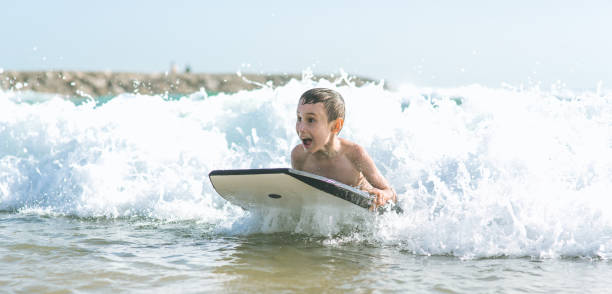 menino de placa do corpo - bodysurfing - fotografias e filmes do acervo