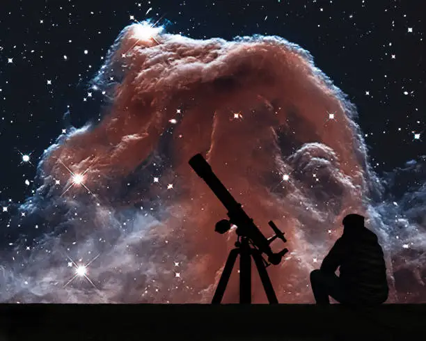 Man with telescope looking at the stars. The Horsehead Nebula in the constellation of Orion (The Hunter)