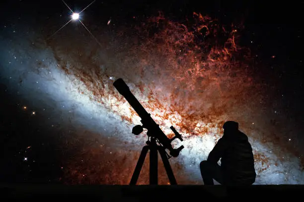 Man with telescope looking at the stars. Messier 82, Cigar Galaxy or M82 in the constellation Ursa Major