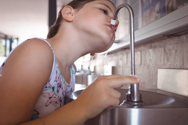 istock Girl drinking water from faucet 824709432