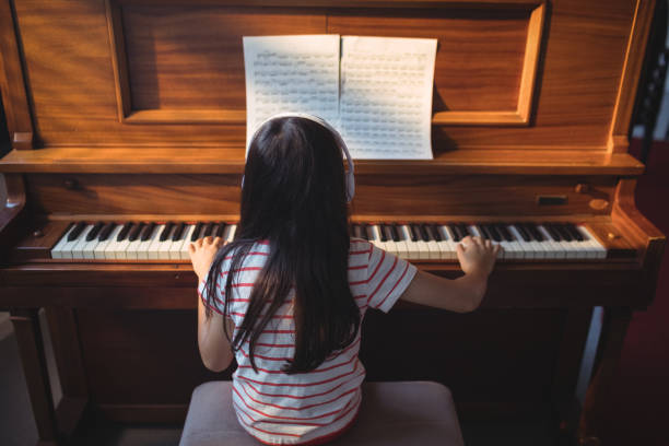 vista traseira da menina praticando piano na sala de aula - chinese pattern audio - fotografias e filmes do acervo