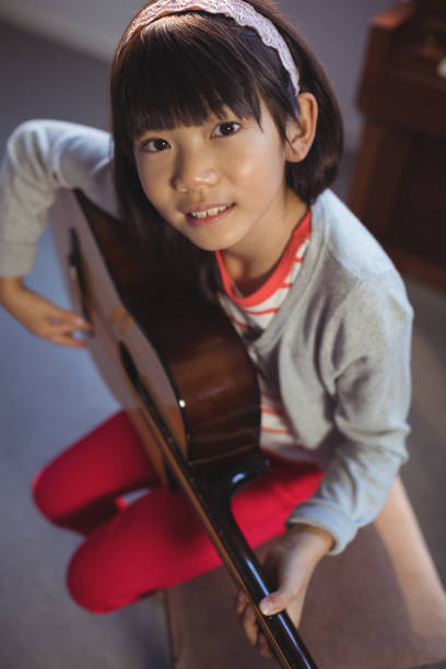 istock High angle portrait of girl practicing guitar 824710094