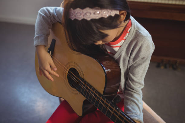 istock High angle view of girl practicing guitar 824710128