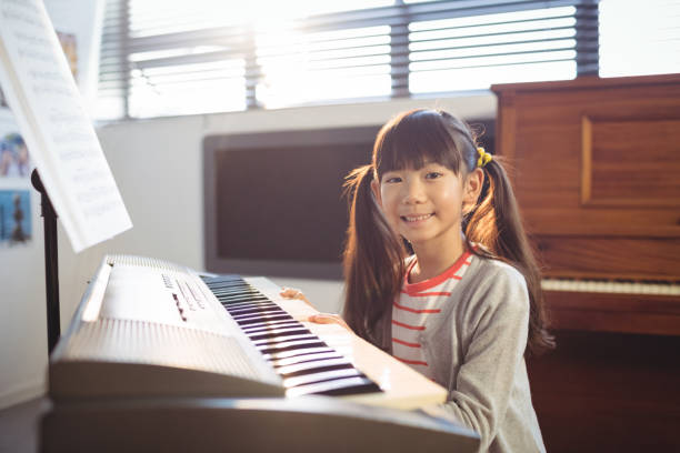 istock Portrait of smiling girl practicing piano 824710166