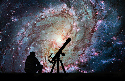 Man with telescope looking at the stars. Messier 83, Southern Pinwheel Galaxy, M83 in the constellation Hydra.