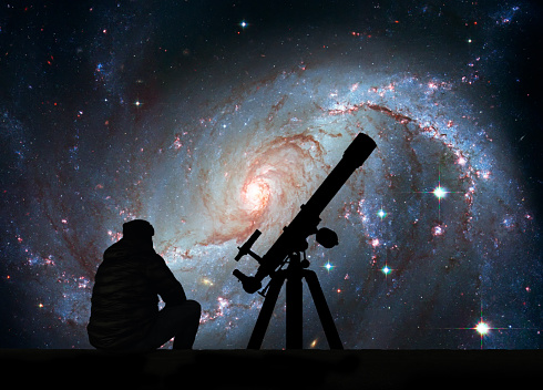 Man with telescope looking at the stars. Stellar Nursery NGC 1672. Spiral galaxy in the constellation Dorado