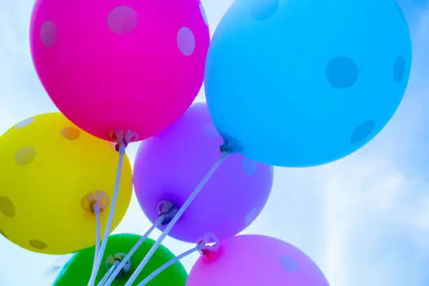 Photo of Colorful balloons on the sky background. Festive air balloons from below.