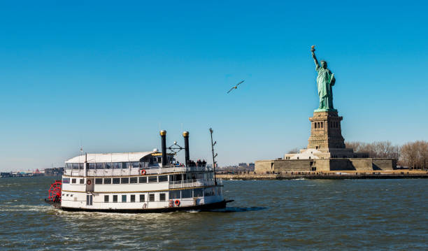 statua della libertà con nave passeggeri a new york city, ny, usa - ferry new york city ellis island new york state foto e immagini stock