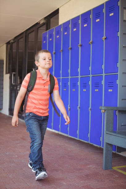 istock Full length of cute boy walking in corridor 824720494